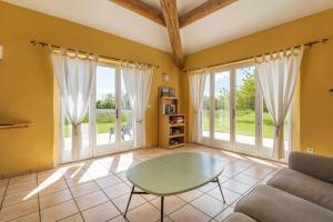 a living room with a glass table and windows at La Bellimure in Saint-Christol
