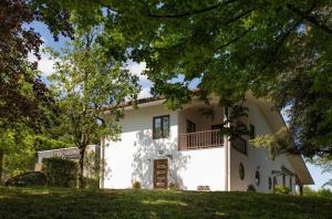 a large white house with a tree in front of it at La Ginestra Appartamenti e Camere in Mossa