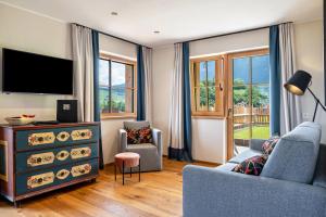 a living room with a blue couch and a tv at Hoamat Schlosshof in Völs am Schlern