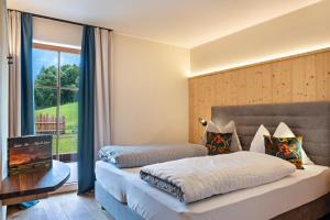 a hotel room with two beds and a window at Hoamat Schlosshof in Völs am Schlern