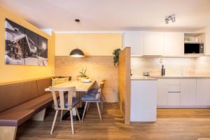 a kitchen and dining room with a table and chairs at Ciasa Rungg App Corones in San Vigilio Di Marebbe