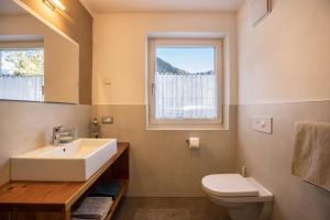 a bathroom with a sink and a toilet and a window at Ciasa Rungg App Corones in San Vigilio Di Marebbe +18 photos