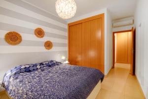 a bedroom with a bed with a blue comforter at Royal Cabanas Golf 81 in Conceição +13 photos