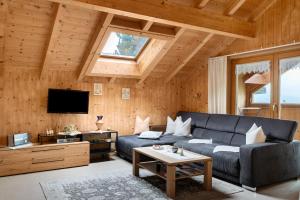 a living room with a couch and a tv at Haus Vögel in Sibratsgfäll