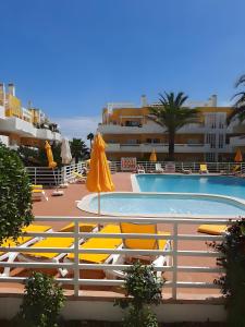 a swimming pool with yellow chairs and umbrellas at Royal Cabanas Golf 81 in Conceição