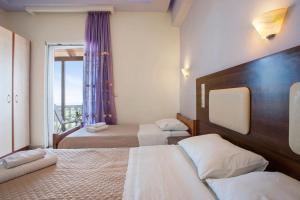 a hotel room with two beds and a window at Zante View Family Studio 1 in Tsilivi +22 photos