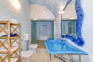 a bathroom with a blue sink and a toilet at Masseria Scafazzi - Salento in Presicce +149 photos