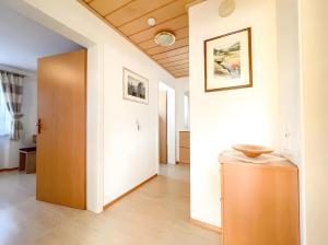 a hallway with white walls and a wooden door at Haus Rosenfelder Fewo Abendsonne in Bernau im Schwarzwald
