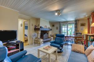 a living room with blue chairs and a fireplace at Location Fontaine de Sarac in Clermont-lʼHérault