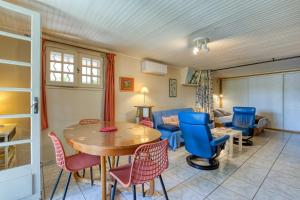 a living room with a table and chairs and a couch at Location Fontaine de Sarac in Clermont-lʼHérault