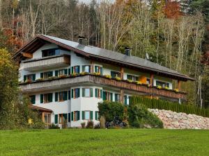 a large white house with a stone wall at Martin´s Alm in Friesenried