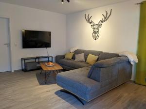 a living room with a couch and a tv at Fewo New Oberdorf in Fautenbach