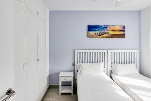 a bedroom with two beds and a desk with a picture on the wall at Casa en Begur reformada in Begur