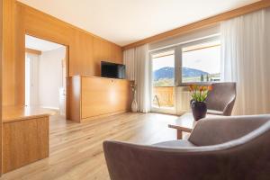ein Wohnzimmer mit Sofa, Tisch und Fernseher in der Unterkunft Passerblick in Dorf Tirol