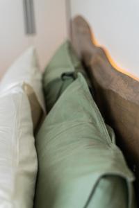 a bed with green sheets and pillows on it at Sofia's central suite in Alexandroupoli +27 photos