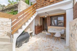 a stone patio with a table and a staircase at Maniaveta's House in Exanthia