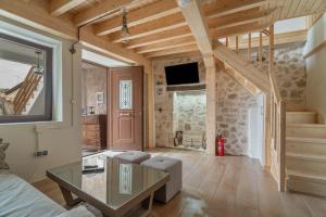 a living room with wooden ceilings and a staircase at Maniaveta's House in Exanthia