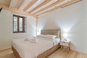 a white bedroom with a bed and a window at Maniaveta's House in Exanthia