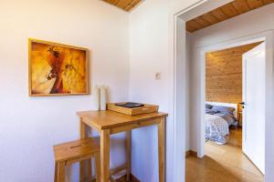 a room with a wooden table with a picture on the wall at Ferienwohnung Kalkau in Lichtenstein