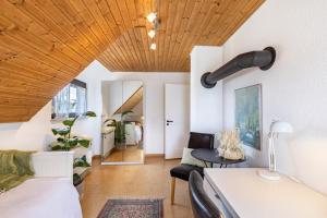 a room with a bed and a couch and a wooden ceiling at Ferienwohnung Kalkau in Lichtenstein