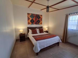 a bedroom with a bed and a painting on the wall at Cabañas el Chañar in San Pedro de Atacama +65 photos