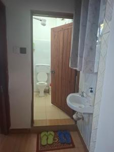 a bathroom with a sink and a toilet and a sink at Bright Homes in Eldoret