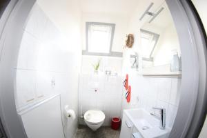 a white bathroom with a toilet and a sink at Ferienhaus 109 - Seepark Kirchheim in Kirchheim +17 photos
