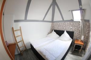 a bedroom with a bed with a ladder and a mirror at Ferienhaus 109 - Seepark Kirchheim in Kirchheim
