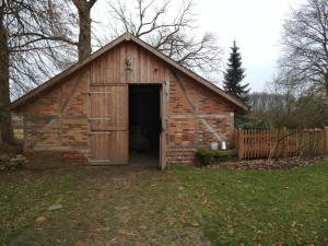 a barn with a door open in a yard at Ferienhaus Melkerhaus in Neetzendorf +3 photos