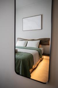 a mirror reflection of a bed in a bedroom at Sofia's central suite in Alexandroupoli