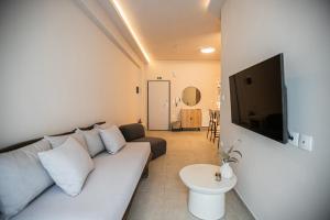 a living room with a couch and a flat screen tv at Sofia's central suite in Alexandroupoli