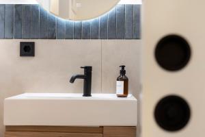 a bathroom sink with a bottle of soap on it at Apartment Anna in Soprabolzano +12 photos