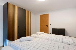 a bedroom with two beds with white sheets at Apartment Anna in Soprabolzano