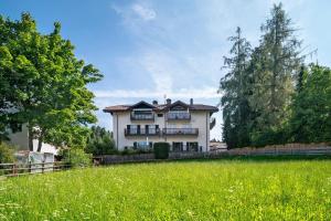 a large white house in a field of grass at Apartment Anna in Soprabolzano