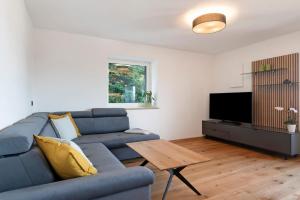 a living room with a blue couch and a table at Apartment Anna in Soprabolzano