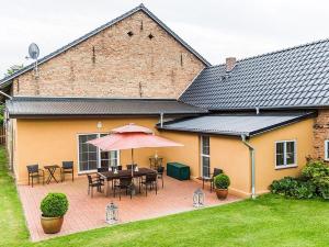 a patio with a table and umbrella in front of a house at Ferienhaus Sükow in Perleberg