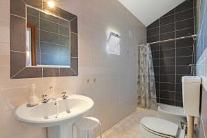 a bathroom with a sink and a toilet and a mirror at Casa dos Jotas in Martinlongo +22 photos