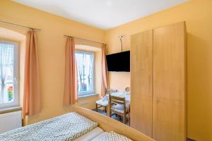 a bedroom with a cabinet and a dining room at Pension Mosellablick in Briedern