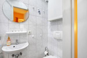 a white bathroom with a sink and a mirror at Pension Mosellablick in Briedern