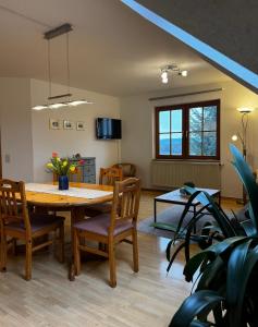 a dining room and living room with a table and chairs at Ferienhof Hanssler in Wilhelmsdorf