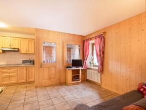 a kitchen with wooden cabinets and a computer on a table at Ciasa Lino Sas da le Doudesc in Pozza di Fassa