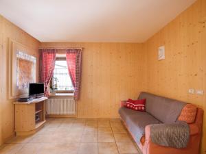 a living room with a couch and a television at Ciasa Lino Sas da le Doudesc in Pozza di Fassa
