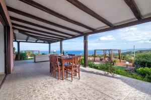 a patio with a table and chairs and the ocean at Villa Patrizia in Castelsardo