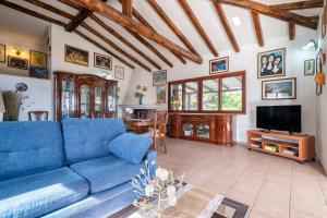 a living room with a blue couch and a tv at Villa Patrizia in Castelsardo