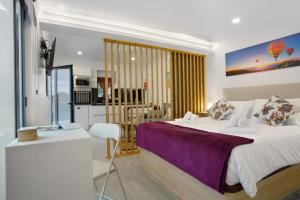 a bedroom with a large bed and a kitchen at Litlle Zen House in Santana