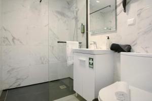a white bathroom with a toilet and a sink at Litlle Zen House in Santana +21 photos