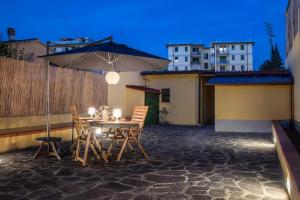 a table and chairs with an umbrella on a patio at Piave House - Pisa in Pisa