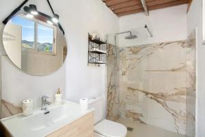 a bathroom with a sink and a mirror and a shower at Casa Cueva in Teror +15 photos