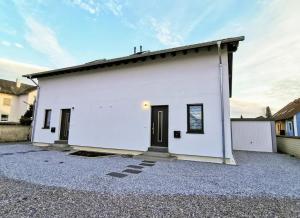 a white building with a black door on a driveway at Ludwig der xvi in Schwandorf in Bayern