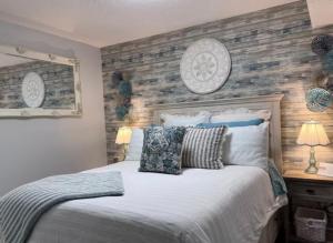 a bedroom with a bed with a wooden accent wall at Harrison Lakeside Retreat in Harrison Hot Springs